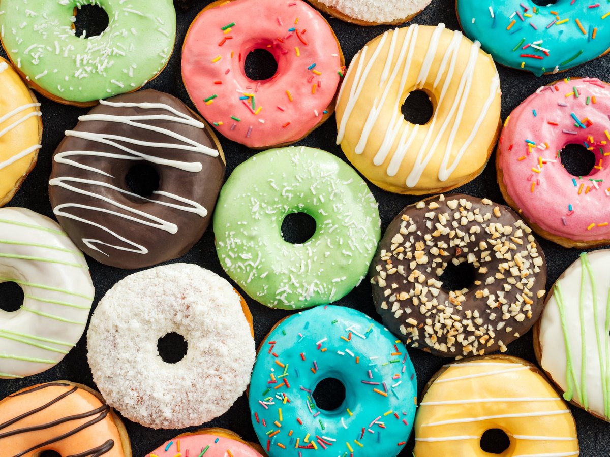 Top view of assorted colorful glazed donuts with sprinkles