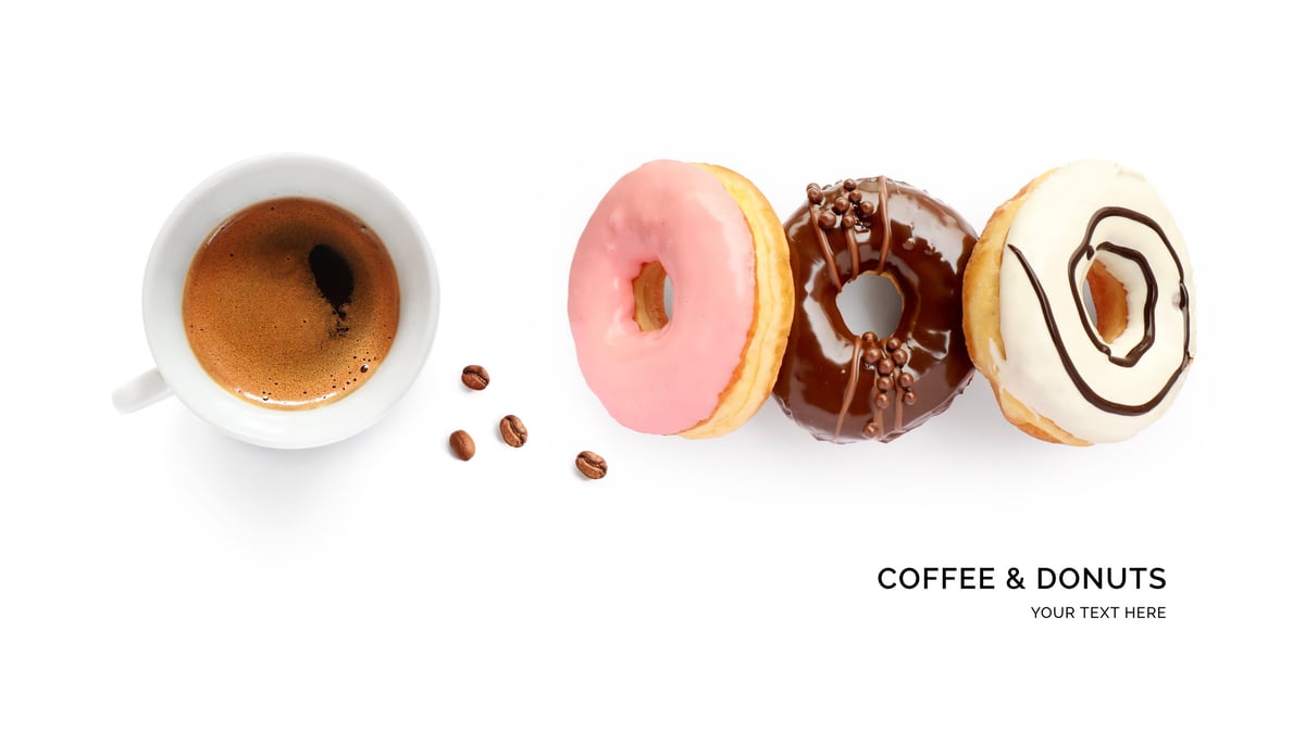 Donuts and coffee arranged in a flat lay on a white background